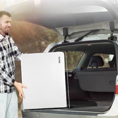 Person carrying EasyCookStation™ for cuisine camping while loading it into an SUV trunk.