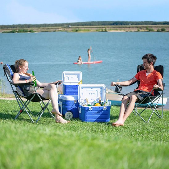 Glacière à roulettes sur la plage, idéale pour conserver boissons et aliments frais en plein air.